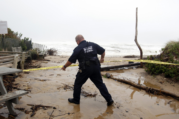 A member of the East Hampton Town Marine Patrol closes off an area of the beach where waves were starting to encroach on land ahead of Hurricane Earl in Montauk, New York September 3, 2010. [Xinhua/Reuters]