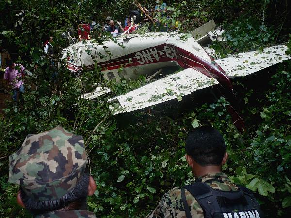 Rescue workers stand around the debris of a crashed plane in Huatulco September 3, 2010. Two members of Mexico's Congress were among six people killed on Friday when their private plane crashed near the popular Mexican Pacific beach resort, officials said. 