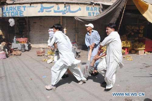  People transfer an injured after the suicide blast in Quetta, Pakistan, Sept. 3, 2010. [Xinhua]