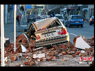 A car lies amid fallen rubble in Christchurch, New Zealand after a powerful earthquake struck much of New Zealand's South Island early Saturday Sept. 4, 2010. [Chinanews.com]