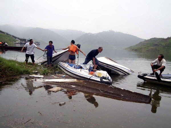 Villagers in a scenic spot in Luoyang try to retrieve boats sunk due to the storm on Sept 4. [Xinhua] 