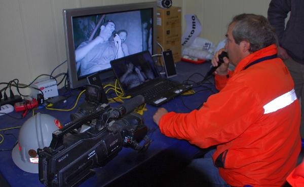 Rescuers talk to the trapped miners in Copiapo, Chile, September 4, 2010. The 33 men trapped deep below ground in a Chilean mine face a grim milestone Sunday, a month since the cave-in that stranded them, as officials warn it could take months more to rescue them. [Xinhua/AFP]