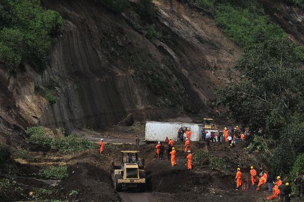 Rescue workers look for survivors at a mudslide area in Nahuala, western Guatemala, Sunday, Sept. 5, 2010. At least 54 people were killed after torrential rains caused mudslides in different areas of the country. [Xinhua/AFP] 