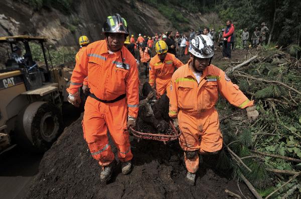 Rescue workers carry the body of a mudslide victim in Nahuala, western Guatemala, Sunday, Sept. 5, 2010. [Xinhua/AFP]