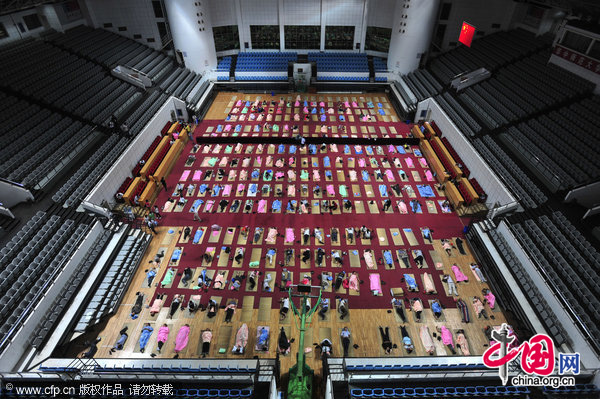 Parents of nearly 400 newly admitted freshman students sleep inside a stadium at Huazhong Normal University in Wuhan, Central China&apos;s Hubei province, Sept 4, 2010. This is the fifth year the university has opened its stadium overnight for parents from poor families. The university provided the parents with free blankets as well as tea and shower services. [CFP]