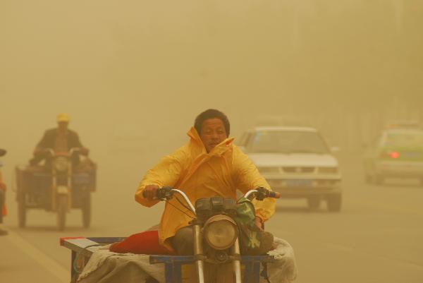 People drive tricycles in sandstorm on a street in Kax, a city in northwest China&apos;s Xinjiang Uygur Autonomous Region, on Sept. 5, 2010. A heavy sandstorm hit Kax on Sunday, lowering the visibility to less than 100 meters in the city.
