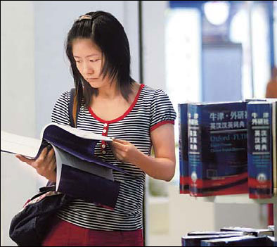 A woman reads the new Oxford English-Chinese, Chinese-English dictionary at the Beijing International Book Fair last week. For the first time, the dictionary now includes some fashionable Chinese words like 'shanzhai', 'youtiao' and 'fangnu', which are popular among netizens. 