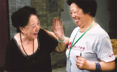 A census taker chats with a resident in downtown Beijing. Some 6 million workers nationwide are helping to register residents' information for the sixth census. 