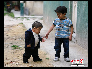 Edward Nino Hernandez (L) walks with his eleven-year-old brother outside their home in Bogota September 6, 2010. [Chinanews.com]