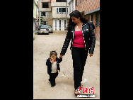 Edward Nino Hernandez walks with his mother Nohemi outside their home in Bogota September 6, 2010. [Chinanews.com]