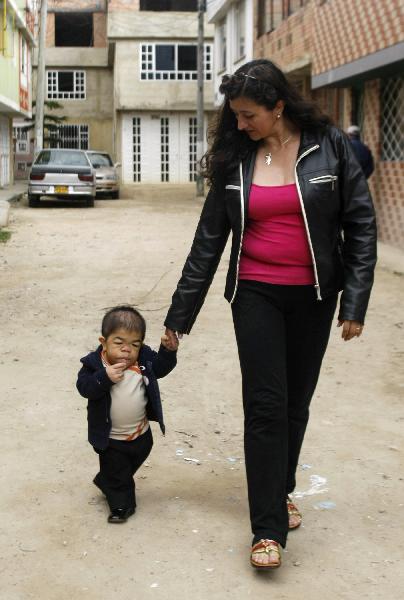 Edward Nino Hernandez walks with his mother Nohemi outside their home in Bogota September 6, 2010. Edward, 24, who is 70.21 cm (2 ft 3.46 inches), has been recognised as the world&apos;s shortest man in the upcoming Guinness World Records 2011 book. [Xinhua]