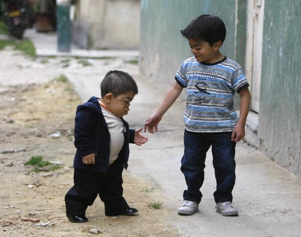 Edward Nino Hernandez (L) walks with his eleven-year-old brother outside their home in Bogota September 6, 2010. Edward, 24, who is 70.21 cm (2 ft 3.46 inches), has been recognised as the world&apos;s shortest man in the upcoming Guinness World Records 2011 book. [Xinhua]