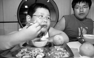 A boy on a diet eats mainly vegetables and fruit at a summer camp for overweight children in Shanghai designed for them to loose weight.
