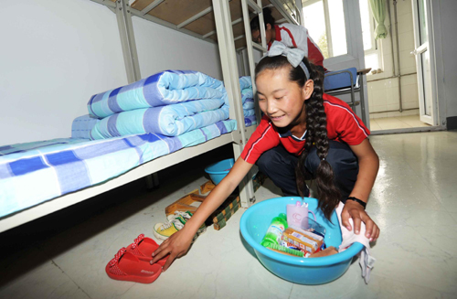 A Tibetan student gets settled in in her new dorm in Shijiazhuang Primary Normal School, North China's Hebei province, on Sept 6. [Photo/Xinhua] 