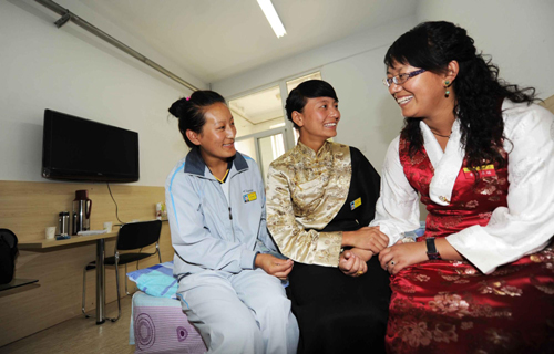 A Tibetan teacher (R) talks with students after their arrival. [Photo/Xinhua] 