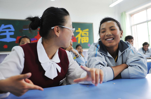 A local student talks with a Tibetan student about the school. [Photo/Xinhua] 