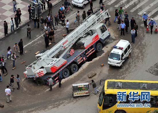 A truck gets stuck in a sink hole on a road in Lanzhou, Northwest China&apos;s Gansu province on Sept 7. The truck, weighing almost 32 tons, was travelling on a main road in downtown Lanzhou when the road gave way beneath it. Torrential rains are blamed for the damage of the road surface. [Xinhua]