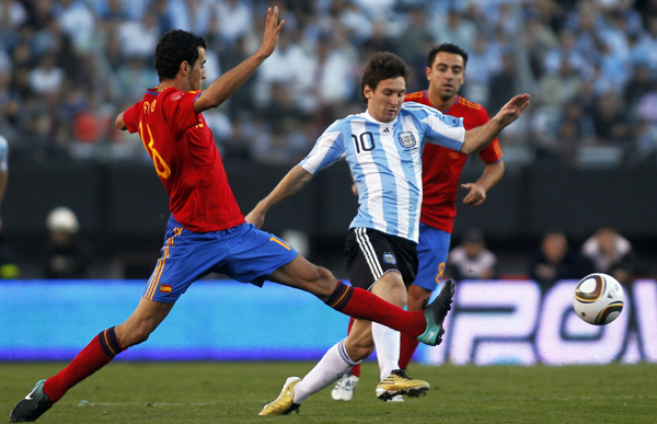 Spain's Sergio Busquets (L) fights for the ball with Argentina's Lionel Messi during their friendly soccer match in Buenos Aires, September 7, 2010. Argentina beats Spain 4-1. (Xinhua/Reuters Photo)