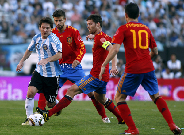 Argentina's Lionel Messi (L) is challenged by Spain's Cesc Fabregas (1st R), Xabi Alonso (2nd R) and Gerard Pique during their friendly soccer match in Buenos Aires, September 7, 2010. (Xinhua/Reuters Photo)