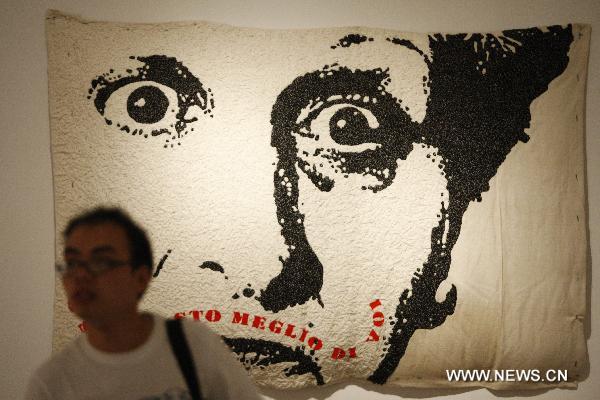 A visitor passes by an embroidery picture created by Italian futurist Sofia Rocchetti during the Italian Futurism Exhibition held in China's National Art Museum in Beijing, capital of China, Sept. 7, 2010.