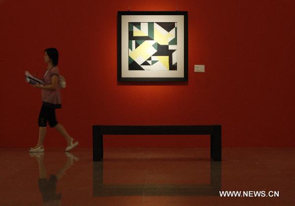 A visitor passes by an artwork created by Italian futurist Giacomo Balla during the Italian Futurism Exhibition held in China's National Art Museum in Beijing, capital of China, Sept. 7, 2010.