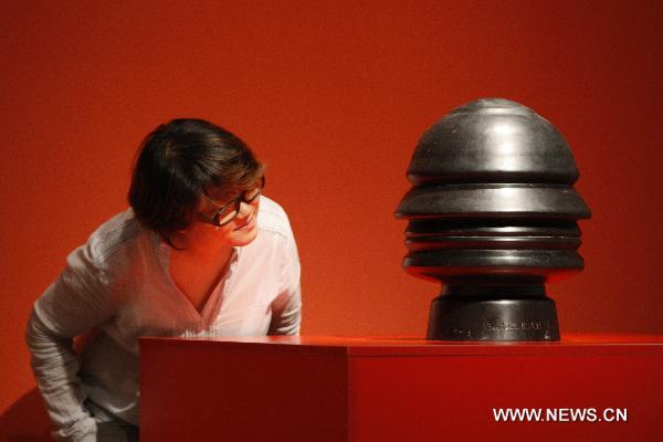 A visitor admires an artwork created by Italian futurist Renato Bertelli during the Italian Futurism Exhibition held in China's National Art Museum in Beijing, capital of China, Sept. 7, 2010.