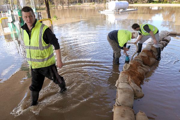 Workers look out from sandbags at a service station forecourt in Shepparton after floods hit northern Victoria, some 200 kms north of Melbourne, September 7, 2010. 