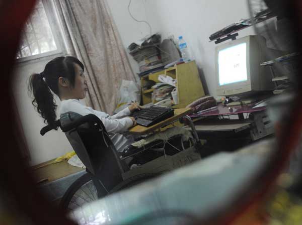Ren Ying, a teacher in a wheelchair, studies on the Internet, Sept 7, 2010. [Xinhua]