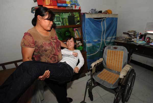 Ren&apos;s family moves her to the wheelchair, Sept 7, 2010. [Xinhua]