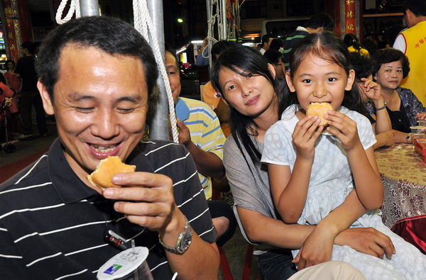 Residents enjoy moon cakes during the Moon Cake Gambling Tournament in Kaohsiung in southwest Taiwan, Sept 8, 2010. [Xinhua]