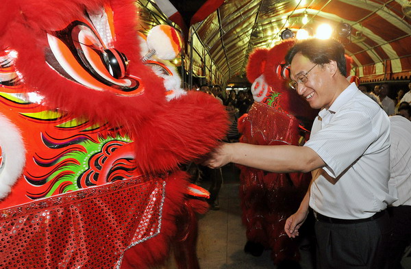 A man hands out red packets to dragon and dance teams during the Moon Cake Gambling Tournament in Kaohsiung in southwest Taiwan, Sept 8, 2010. [Xinhua]