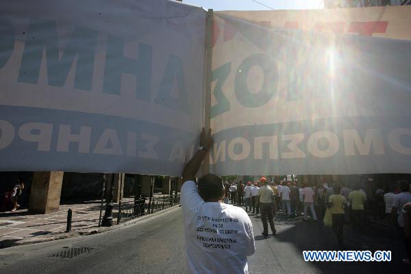 A demonstrator holds a banner in Athens, capital of Greece, Sept. 8, 2010. [Marios Lolos/Xinhua]