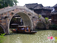 With a history of 1,200-year, Wuzhen is about one hour's drive from Hangzhou,the capital of Zhejiang Province.The small town is famous for the ancient buildings and old town layout, where bridges of all sizes cross the streams winding through the town.  [Photo by Hu Di]