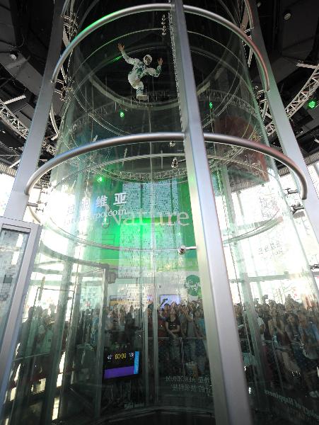 A Latvian acrobat performs in a wind tunnel which blows off winds of 200 kilometers per hour from the bottom, in the Latvia Pavilion in the Shanghai World Expo Park in Shanghai, east China, Sept. 8, 2010. 