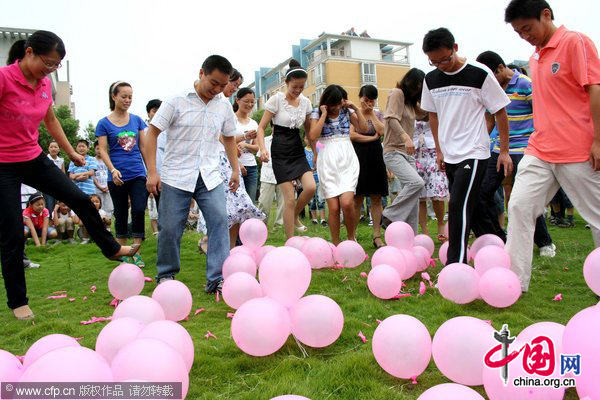 Teachers step on balloons during an event to celebrate the upcoming Teachers&apos; Day at an elementary school in Hanshan, East China&apos;s Anhui province, Sept 9, 2010. [CFP] 