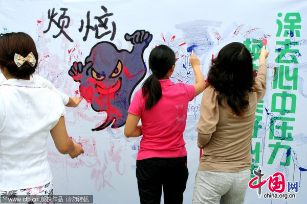 Teachers apply graffiti on a wall during an event to celebrate the upcoming Teachers&apos; Day at an elementary school in Hanshan, East China&apos;s Anhui province, Sept 9, 2010. [CFP] 