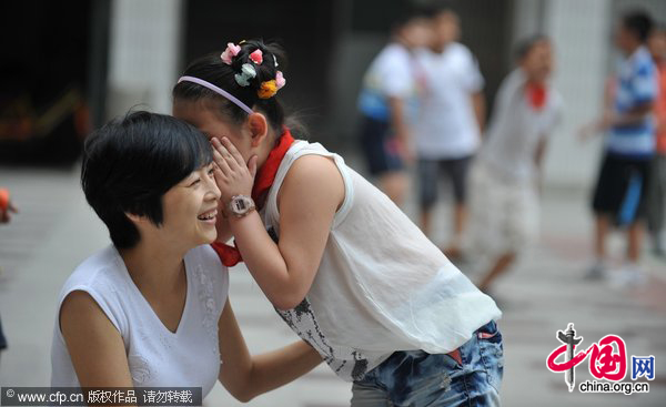 A student wispers in her teacher&apos;s ear to give a wish for upcoming Teacher&apos;s Day in Hongqiao primary school, Hefei, Anhui Province, September 9, 2010. [CFP]