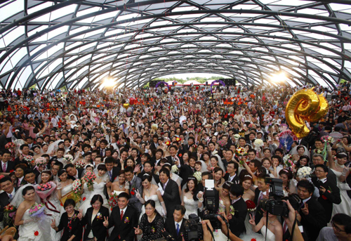 Couples pose for a group photograph with Taipei Mayor Hau Lung-bin (bottom, 5th L) during a mass wedding ceremony at the Taipei Flora Expo Hall Sept 9, 2010. A mass wedding ceremony was held for 163 couples on Thursday on the ninth day of the ninth month. The date is an auspicious number as the number nine (pronounced jiu in Chinese) is a homophone that means lasting. [China Daily/Agencies]