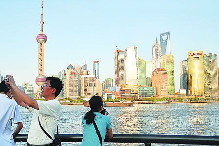 Visitors take pictures by the Huangpu River. Photo: Cai Xianmin 