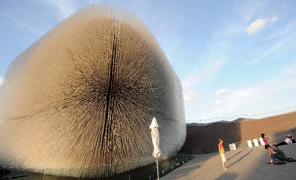 A visitor has photos taken outside the Seed Cathedral, the pavilion of the United Kingdom, at the Expo Park in east China's Shanghai Sept. 9, 2010.