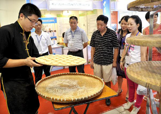 A staff member of a food enterprise performs cooking precedure of a kind of traditional cake during the 7th China Time-honored Brand Exposition held in Hangzhou, capital of east China's Zhejiang Province, Sept. 9, 2010. The 5-day exposition kicked off on Thursday, with the participation of nearly 200 time-honored enterprises across the country. [Xinhua photo]
