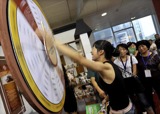 A visitor tries luck on a swivel table during the 7th China Time-honored Brand Exposition held in Hangzhou, capital of east China's Zhejiang Province, Sept. 9, 2010. The 5-day exposition kicked off on Thursday, with the participation of nearly 200 time-honored enterprises across the country. [Xinhua photo]