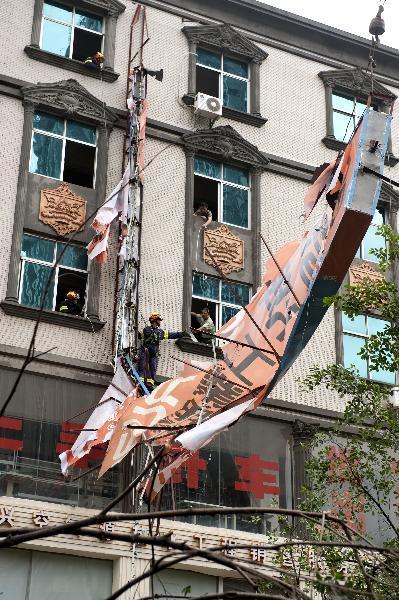  Firefighters pull down an advertisement board damaged by the typhoon Meranti in downtown Shishi, southeast China's Fujian Province, Sept. 10, 2010. Meranti, the 10th typhoon that hit China this year, made landfall at Fujian on Friday, according to provincial flood control authorities.