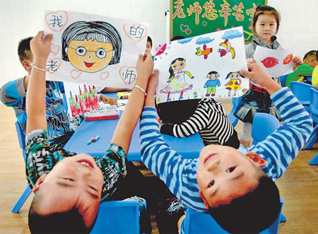 Children from a kindergarten in Huaibei, Anhui province, present handmade cards on Thursday to their teachers for the upcoming Teachers' Day. 