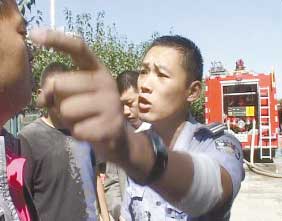 A security guard attempts to block reporters from a campus fire. Photo: dbw.cn