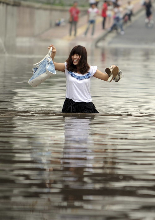 A girl wades through a flooded street after heavy rains brought by tropical storm Meranti in Hangzhou, East China&apos;s Zhejiang province, Sept 12, 2010. [Xinhua]