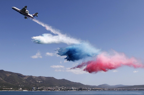 Russian-made Beriev Be-200ChS amphibious aircraft dumps coloured water as Russian state flag during a demonstration flight at the international air show &apos;Gydroaviasalon 2010&apos; in the Black Sea town of Gelendzhik September 12, 2010.[China Daily/Agencies] 