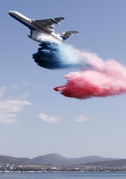 Russian-made Beriev Be-200ChS amphibious aircraft dumps coloured water as Russian state flag during a demonstration flight at the international air show &apos;Gydroaviasalon 2010&apos; in the Black Sea town of Gelendzhik September 12, 2010.[China Daily/Agencies] 