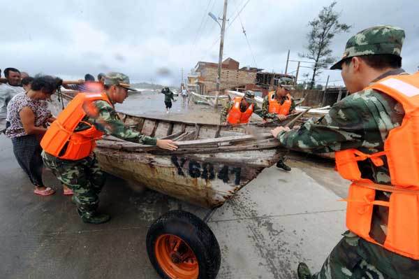 Soldiers help people evacuate fishing boats, as tropical storm Meranti made landfall in Fujian at 3:30 am on Friday. [Photo/Xinhua]