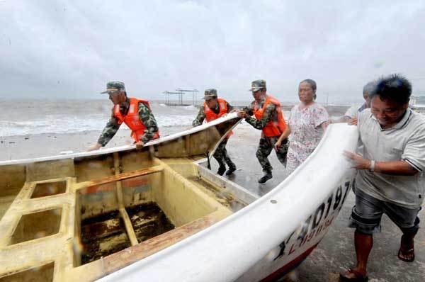 Soldiers help people evacuate fishing boats, as tropical storm Meranti made landfall in Fujian at 3:30 am on Friday. [Photo/Xinhua]